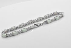 Here we have a beautiful lab created White Opal Sterling Silver tennis Bracelet. Opals feature cabochon oval cut in prong setting. Bracelet is about 5 carats of gemstone total weight. This bracelet was designed to allure and impress. It will be an excellent addition to a jewelry collection due to its unique design. The bracelet is made out of solid 925 Sterling Silver and 14k white gold overlay for that timeless and classic look. Brand new item, never worn. Other lengths available per especial r Fine Jewelry Cabochon Bracelets As Gift, Oval Cabochon White Gold Jewelry, Silver Oval Cabochon Bracelet, Formal Oval Sterling Silver Bracelet With Polished Finish, Elegant Silver Cabochon Bracelets, Elegant Sterling Silver Bracelet With Cabochon, Elegant Sterling Silver Cabochon Bracelet, White Oval Jewelry With 17 Jewels, White Gold Oval Cabochon Jewelry For Formal Occasions