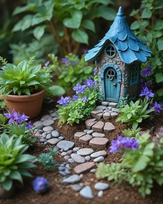 a small house sitting in the middle of a garden filled with plants and rocks next to a potted plant