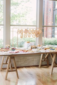 a table with food on it in front of a large window at a wedding reception