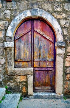 an old wooden door with stone steps leading up to it