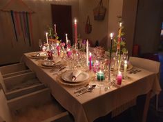 a long table with candles and plates on it is set for a formal dinner or party