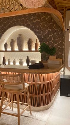 a bar with stools and vases on the counter