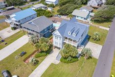 an aerial view of a home in the middle of a street with lots of trees