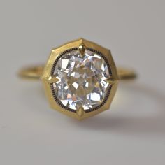 a close up of a diamond ring on a white surface