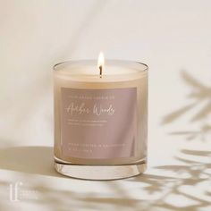 a candle that is sitting next to a white wall with the words, angel wings on it