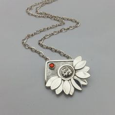 "Handmade Silver Daisy Flower Necklace - This beautiful silver daisy flower necklace is completely handmade using fine silver and is a member of my Garden Inspiration Collection.  Each petal was hand sculpted and carefully shaped to look like a real daisy petal.  I designed and created the texture for the center of the flower and the background of the pendant, then all of the pieces were beautifully assembled.  A fire opal cubic zirconia cabachon was then added for a pop of color.  A sterling si Elegant Silver Necklace With Sunflower Design, Silver Sunflower Design Flower Necklace, Silver Sunflower Design Necklace, Handmade Silver Flower Necklace For Anniversary, Silver Sunflower Pendant Jewelry, Silver Sunflower Pendant Necklace, Silver Necklace With Sunflower Pendant, Silver Jewelry With Sunflower Design Flower Pendant, Recycled Silver Jewelry