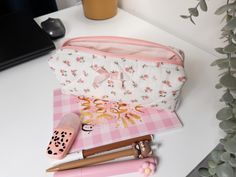 Elevate your stationery game with this Handmade Quilted Floral Pencil Case featuring a charming pink bow. Perfect for students, professionals, or anyone who loves to keep their desk organized, this cute pencil case doubles as a stylish stationery organizer. Crafted with care from soft cotton fabric, the delicate floral pattern and quilted design add a touch of elegance to your daily routine. Whether you're heading back to school or looking for a unique gift, this zipper pouch is versatile enough Pink Rectangular Pencil Case For Study, Pink Zipper Pouch Pencil Case For Study, Cute Pink Stationery For Everyday Use, Pink Pencil Case With Zipper Pouch For Organization, Pink Zipper Pouch Pencil Case For Organization, Cute Pink Stationery For Personal Use, Pink Portable Stationery For School, Pink Stationery With Pen Slots For Organization, Cute Pink Stationery For Daily Use