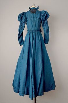 "An absolutely remarkable set from the late 1800's, beautifully designed and constructed, truly from another era. This two-piece dress is in nearly immaculate condition, remarkable given its age. The top is wonderfully constructed, with extensive boning on the interior to give it its shape. Has full sleeves with hook-and-eye closures at wrists. There is a band of ruching around the upper arm, which lead to very voluminous puffed shoulders. Has a high stand collar with bows at each side, and a ga Blue Victorian Dress With Fitted Bodice For Formal Occasions, Elegant Fitted Victorian Dress For Vintage Fashion, Elegant Victorian Dress For Vintage Fashion, Victorian Ball Gown For Vintage Events, Historical Ball Gown Dresses For Formal Occasions, Historical Formal Ball Gown Dresses, Blue Victorian Dress For Costume Events, Victorian Dress With Historical Design For Evening, Fitted 18th Century Ball Gown Dress