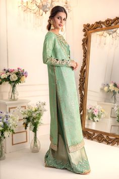 Add a touch of drama & elegance to your wardrobe this wedding season with our stylish ensemble, flowing silhouette paired with zardozi embroidered Blouse & dhaka pants for elongated and sleek look. Stunning embroidered dupatta with pearl & zardozi motifs finishes the look. Shirt & Dupatta Fabric: Pure Embroidered Maysuri NetDhaka Pant & Choli Fabric: Pure soft TissueColor: Caribbean Green This outfit is only available in Custom size, once order is placed design team will contact you for measurem Festive Tissue Silk Palazzo Set With Zari Work, Embroidered Tissue Silk Kurta For Reception, Festive Tissue Silk Palazzo Set, Chanderi Sharara For Reception During Eid, Embroidered Raw Silk Palazzo Set For Reception, Embroidered Raw Silk Palazzo Set With Traditional Drape, Festive Kurta With Resham Embroidery On Tissue Silk, Embroidered Raw Silk Palazzo Set, Designer Tissue Silk Sharara For Transitional Season