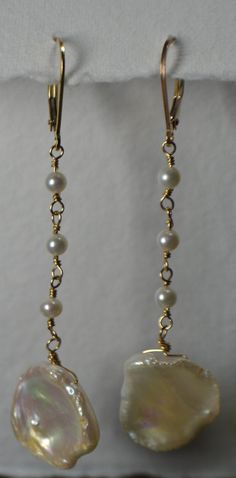 Pearls are the Birthstone for the Month of June and serve as the 3rd and 30th Wedding Anniversary Precious Stone. These Gorgeous Keshi Pearls, or Cornflake Pearls, make for a pair of Earrings that feel Natural and Feminine. Each Keshi Pearl is accented by Hand-Wired Round Freshwater Pearls. Displayed in Beautiful 14k Gold Fill above, these Earrings are also available in Sterling Silver and 14k Rose Gold Fill (Gorgeous for Fall Weddings) >Complete your Bridal look or gift to your Bridesmaids a Adjustable Yellow Gold Earrings For Anniversary, Gold Jewelry With Ear Wire For Anniversary, Yellow Gold Dangle Jewelry For Wedding, Elegant Round Wire Wrapped Jewelry, Elegant Formal Wire Wrapped Jewelry, Teardrop 14k Gold Filled Pearl Earrings For Anniversary, 14k Gold Filled Teardrop Pearl Earrings For Anniversary, Pear-shaped Pearl Drop Jewelry For Anniversary, Delicate Matching Earrings For Anniversary