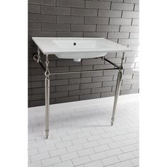 a white sink sitting on top of a metal stand in front of a brick wall