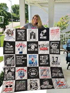 a woman is holding up a quilt that has pictures on it