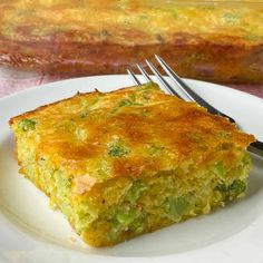 a piece of broccoli casserole on a white plate with a fork