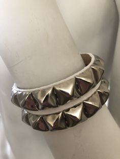 "Classic punk bracelet with two rows of pyramid studs. Studs are 1/2\" across. Studs are steel with nickel plating, hardware is brass with nickel plating. Made with hand dyed vegetable tan leather. Pink sparkle leather is an additional coating applied over dyed leather and may flake off a little around where the buckle fastens. Note: 5.5\"-6.25\" and 6.5-7.25\" bracelets have snaps instead of buckles. The studs are closer together on these than the other bracelet, see pix for details. For best r Silver Punk Bracelets With Studs, Punk Style Silver Bracelet With Studs, Party Leather Bracelet With Rivets, Silver Spiked Bracelets For Parties, Adjustable Silver Bracelet With Spikes, Trendy Party Bracelets With Rivets, Metal Studs Bracelets For Party, Metal Bracelets With Studs For Party, Edgy Silver Leather Bracelet With Spikes