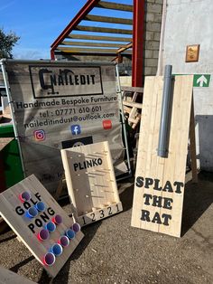 several pieces of wood sitting in front of a sign and some sort of box on the ground