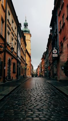 an empty cobblestone street with buildings in the background