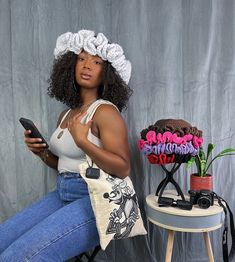 a woman sitting on a chair holding a cell phone