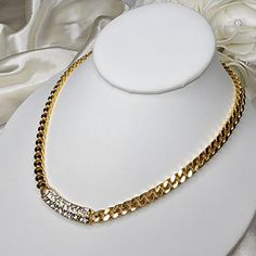 Gorgeous vintage gold tone necklace features a pave set rhinestone center, fastened with two lengths of heavy, shiny Cuban chain. Lobster clasp closure. There is a definite stamp on the back, but am unable to discern. A beautiful piece in excellent pre-loved condition! Gold Chain Link Necklace With Diamond Accents, Gold Chain Necklace With Diamond Accents, Gold Chain Link Rhinestone Necklace For Party, Gold Necklace With Bling For Formal Occasions, Formal Gold Necklace With Bling, Formal Gold Bling Necklace, Gold Chain Link Necklace With Rhinestones, Elegant Cuban Link Bling Chain Necklace, Elegant Cuban Link Chain Necklace With Bling