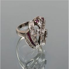 Impressive Vintage Designer Diamond and Ruby Size 4.5 Ring This lovely 14K white gold and diamond ring contains 18 round brilliant and single-cut diamonds weighing approx. .50 CTW and rated approx. VS-SI in clarity and H-I in color. 7 round and square faceted rubies weighing approx. .20 CTW make this ring really POP! Size: 4.5. Weight: 7.2 grams. It can be re-sized at your favorite jeweler. Only One AvailableA similar Ring Sells for $3,375 - 1stdibsPristine Condition - Guaranteed & CertifiedFree Elegant Platinum Ruby Ring With Round Cut, Elegant Ruby Ring In White Gold And Platinum, White Gold Ruby Ring In Platinum, Elegant Diamond White Ruby Ring With Brilliant Cut, Elegant Diamond White Ruby Ring, Luxury White Ruby Ring With Brilliant Cut, Elegant White Gold Ruby Ring In Platinum, Elegant Round Cut Diamond Ring With 17 Jewels, White Ruby Ring With Vvs Clarity