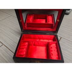 an open red velvet jewelry box on the floor