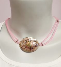 This abalone shell and pink bead short necklace is the perfect piece to add a touch of boho chic style to any outfit. The necklace features 2 strands of pink cylindrical beads, giving it a unique and eye-catching look. The abalone shell bring s a subtle iridescent shimmer to the necklace, while the pink beads compliment the dome shaped abalone shell.  Whether you're looking for a statement piece or something more subtle, this abalone shell and pink bead short necklace is the perfect addition to any jewelry collection. Bohemian Adjustable Pink Shell Necklace, Pink Double Strand Handmade Necklaces, Pink Handmade Double Strand Necklaces, Handmade Pink Double Strand Necklaces, Adjustable Pink Shell Jewelry, Adjustable Pink Beaded Shell Necklace, Pink Adjustable Shell Jewelry, Adjustable Pink Choker For The Beach, Pink Adjustable Shell Necklace As Gift