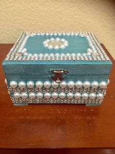 a blue box with pearls on it sitting on a table