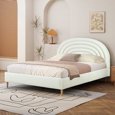 a white bed sitting on top of a wooden floor