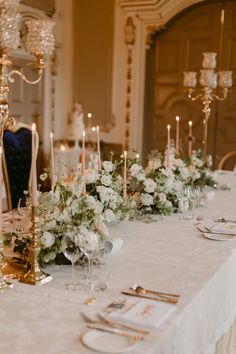 the table is set with candles, flowers and place settings for an elegant wedding reception