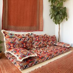 a couch sitting on top of a rug next to a potted plant