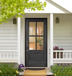 the front door of a house with flowers and plants