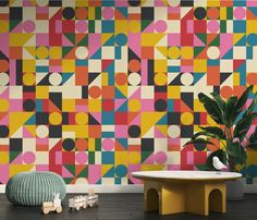 a colorful wallpaper with geometric shapes on it and a round table in the foreground