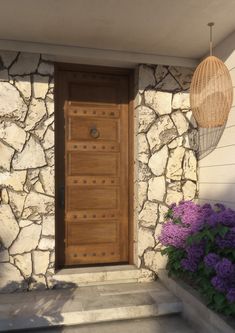 a wooden door sitting on the side of a stone building next to flowers and plants