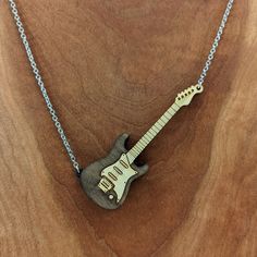 This electric guitar pendant is made from birch wood and comes on an 18” black, gold, or silver stainless steel chain. The electric guitar pendant measures approximately 3.25” tall x 1.25 wide. Engrave the back with the wording of your choice. Due to size please keep the text under 15 characters, including spaces. Free shipping for US customers. The item ordered comes in a cute gift bag. Items shown in the gift bag in the photo are for illustrative purposes. Every piece of wood is naturally diff Guitar Necklace, Guitar Pendant, Music Jewelry, Guitar Design, Black Chain, Engraved Necklace, Cute Gift, Black Stainless Steel, Steel Jewelry