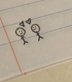 two stick figures are drawn on lined paper