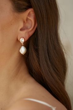 a woman wearing earrings with pearls on them