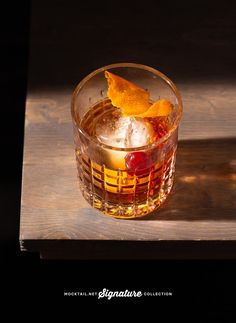 a close up of a drink in a glass on a wooden tray with ice and fruit