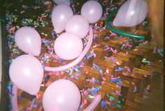 pink balloons and streamers are on the floor