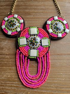 a pair of colorful beaded necklaces on a wooden table