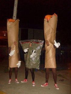 three people dressed up as birds holding bags