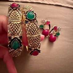 Elevate Your Style With This Stunning Set Of Two Bangles And Matching Earrings, Adorned With Large Green, Pink, And White Stones. The Vibrant Blend Of Colors Adds A Touch Of Glamour To Your Ensemble, Making It A Perfect Choice For Both Festive Occasions And Everyday Elegance. These Meticulously Crafted Accessories Reflect A Harmonious Balance Of Tradition And Contemporary Style, Making A Bold Statement Wherever You Go. Embrace The Brilliance Of These Bangles And Earrings, Celebrating The Vivid B Trendy Multicolor Festive Jewelry, Festive Multicolor Trendy Jewelry, Multicolor Metal Jewelry Sets For Party, Pink Jewelry Sets With Matching Round Earrings, Trendy Jeweled Earrings For Gift, Trendy Festive Drop Earrings, Pink Jewelry Sets With Matching Earrings, Multicolor Bangle For Party, Trendy Gold Jewelry For Festive Occasions