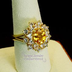 Thank you for coming in! This Vintage Ring has a strong striking yellow sapphire as its center piece. The sapphire is bezel set into a fancy setting with 8 heart and 8 round diamonds totaling 1.8 carats! Ring Size: 7.75 Total Weight: 9.58 grams Precious Metal: 18k solid gold Precious stones: -Yellow Sapphire: 2.92 carats, 9mm x 7.3mm -White Round Diamonds: 1.8 ct Hallmark: A18K Fine Yellow Oval Sapphire Ring, Elegant Yellow Jewelry With Center Stone, Oval Yellow Sapphire Ring With Center Stone, Yellow Multi-stone Sapphire Ring, Gold Diamond Ring With Sapphire Center Stone, Fine Jewelry With Yellow Sapphire And 17 Jewels, Yellow Oval Sapphire Ring With Prong Setting, Fine Jewelry Yellow Topaz Ring With Halo Setting, Exquisite Gold Multi-stone Sapphire Ring