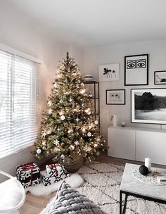 a living room with a christmas tree and pictures on the wall