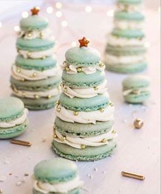 green macaroons with white frosting and gold sprinkles on a table