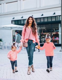 a woman and two children walking down the street