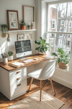 a desk with a computer on it in front of a window and potted plants