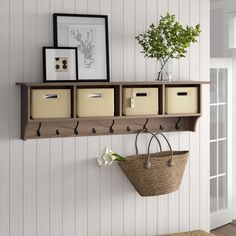 a shelf with some baskets and pictures hanging on it's sides next to a door