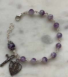 Catholic Rosary Bracelet: 6 and 8mm amethyst bracelet   Solid sterling silver wire, clasp, chain and medals. Hand Wrapped Purple Round Jewelry, Adjustable Silver Rosary Bracelet For Healing, Nickel Free Purple Bracelets, Hand Wrapped Round Purple Jewelry, Silver Spiritual Rosary Bracelet For Healing, Silver Rosary Bracelet With 8mm Beads For Healing, Silver Rosary Bracelet With Natural Stones As Gift, Silver Amethyst Bracelets Hand Wrapped, Spiritual Sterling Silver Wire Wrapped Bracelets