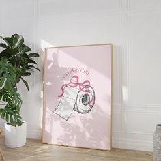 a pink poster with a roll of toilet paper on it next to a potted plant