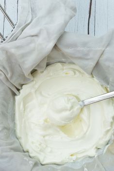 a bowl filled with cream sitting on top of a table