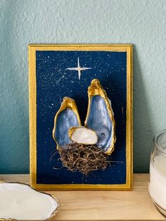 a nativity scene is displayed on a shelf next to a glass bowl and candle